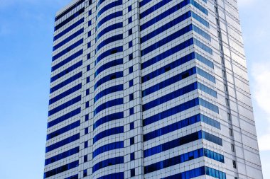 Gökyüzüne karşı mavi pencereli modern gökdelenler..