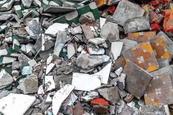 Kırık renkli kiremitler ve beton döküntüleri yığını.