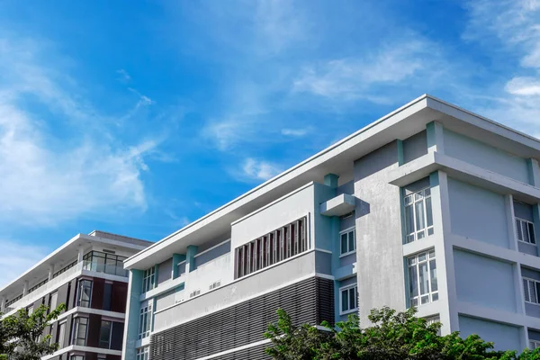 Açık mavi gökyüzüne karşı modern iskan binası.