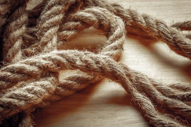 Ahşap yüzeyde sarmalanmış kaba halatın yakın çekimi.