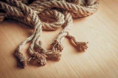 Yıpranmış halatın yakın çekimi ahşap yüzeyde biter..