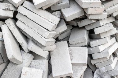 Çeşitli yönelimlerde ve istiflerde beton tuğla yığını.