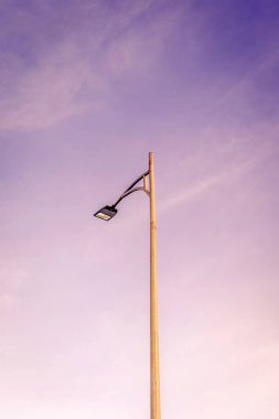 Yumuşak mor gökyüzüne karşı minimalist sokak lambası.