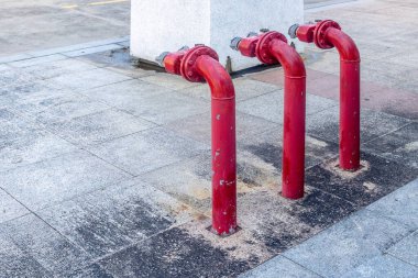 Kentsel beton kaldırımda üç kırmızı yangın musluğu..