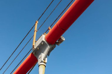 Açık mavi gökyüzüne karşı kırmızı endüstriyel boru yapısı.