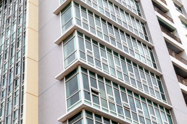 Modern urban high-rise building with multiple glass windows and balconies.