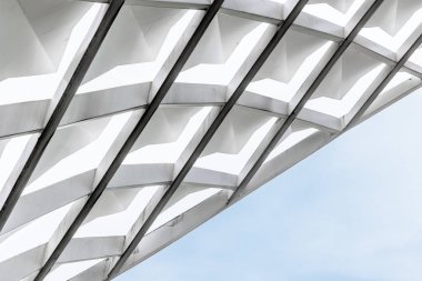 Mavi gökyüzüne karşı beyaz yapıları olan modern geometrik mimari.