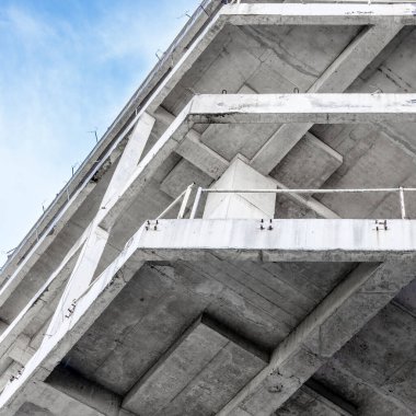 Modern concrete structure with geometric lines against a clear blue sky.