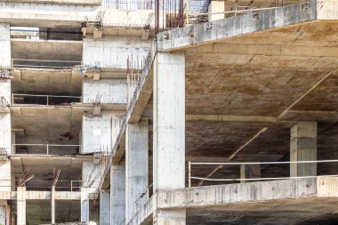 Concrete skeleton of unfinished building in urban construction site.
