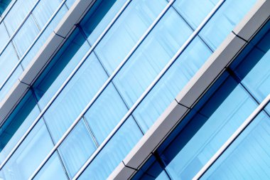 Modern glass architecture with reflective blue windows and geometric design.