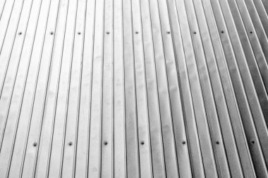 Corrugated metal wall with vertical lines and screw detailing.