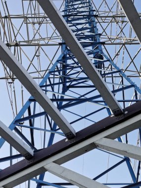 Güç hatları mavi arkaplanda aşağıdan yukarıya doğru yakın mesafeden çekiliyor