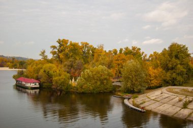 Sonbahar manzarası mavi gökyüzü arka planında bir gölde yansıması olan