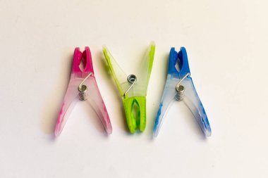 Açık arkaplanda üç plastik mandal.