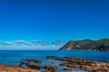 Sardunyalı sahil ve plaj Porto Ferro yaz bulutlu sabah görünümü