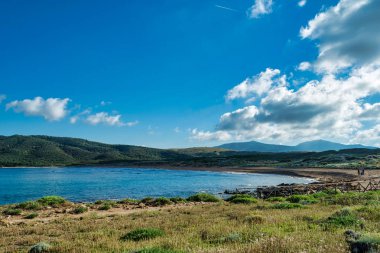 Sardunyalı sahil ve plaj Porto Ferro yaz bulutlu sabah görünümü
