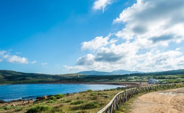 Sardunyalı sahil ve plaj Porto Ferro yaz bulutlu sabah görünümü