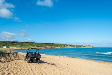 Siyah dört üzerinde Sardunyalı beach, Porto Ferro yaz bulutlu bir sabah