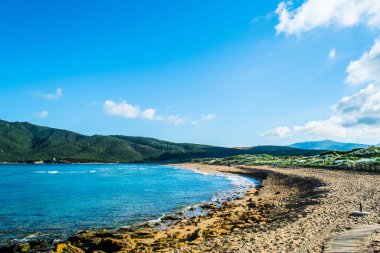 Sardunyalı sahil ve plaj Porto Ferro yaz bulutlu sabah görünümü
