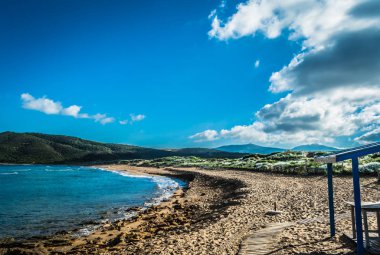 Sardunyalı sahil ve plaj Porto Ferro yaz bulutlu sabah görünümü