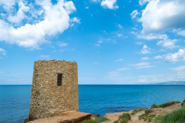 Antik Abbacurrente Kulesi, bulutlu ve güneşli bir günde bahar Asinara Körfezi yakınlarında Porto Torres şehir