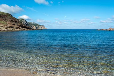 Sardunyalı sahil ve plaj Porticciolo - Alghero - yaz bulutlu sabah görünümü