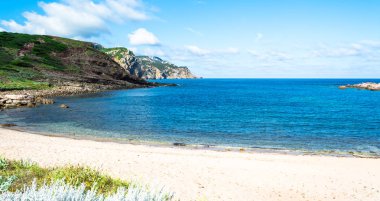 Sardunyalı sahil ve plaj Porticciolo - Alghero - yaz bulutlu sabah görünümü