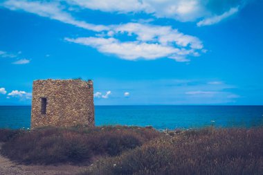 Antik Abbacurrente Kulesi, bulutlu ve güneşli bir günde bahar Asinara Körfezi yakınlarında Porto Torres şehir