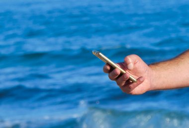 Erkek el Smartphone denize sıfır plaj kullanma