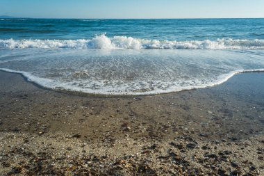 Dalgalar çöl plajın kumları üzerinde