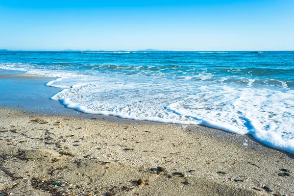 Dalgalar çöl plajın kumları üzerinde