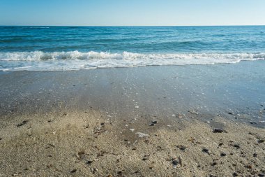Dalgalar çöl plajın kumları üzerinde