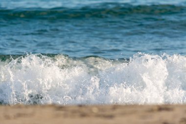 Berrak dalgalar yaz aylarında plajın kumları üzerinde
