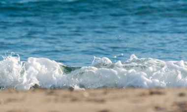 Berrak dalgalar yaz aylarında plajın kumları üzerinde