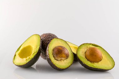 Beyaz arka plan üzerinde izole bütün ve kesme avokado