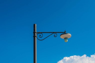 sokak lambasının altında mavi bir gökyüzü ve yumuşak bulutlar