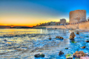 View of Alghero towers at sunset clipart