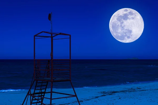 Torre roja de rescate en la playa por la noche — Foto de Stock