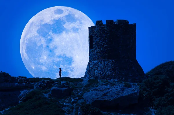 Silueta del hombre y antigua torre bajo super luna — Foto de Stock