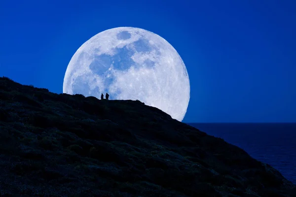 Silueta de los hombres bajo la super luna — Foto de Stock