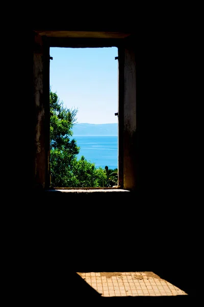Окно старого заброшенного здания с видом на море — стоковое фото