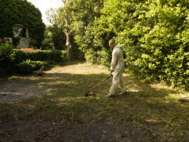 Fırça kesici kullanan adam