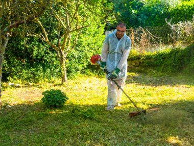 Fırça kesici kullanarak bahçıvan