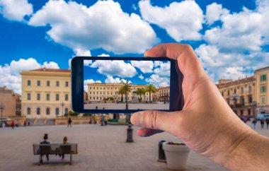 Güneşli bir günde fotoğraf çeken akıllı telefon ile el