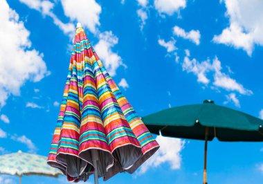 Yaz bulutlu bir günde deniz tarafından çok renkli plaj şemsiyesi
