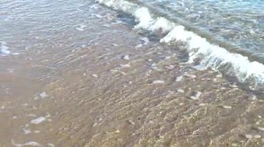Bir yaz sabahı sahilde deniz suyunun yavaş akışı.