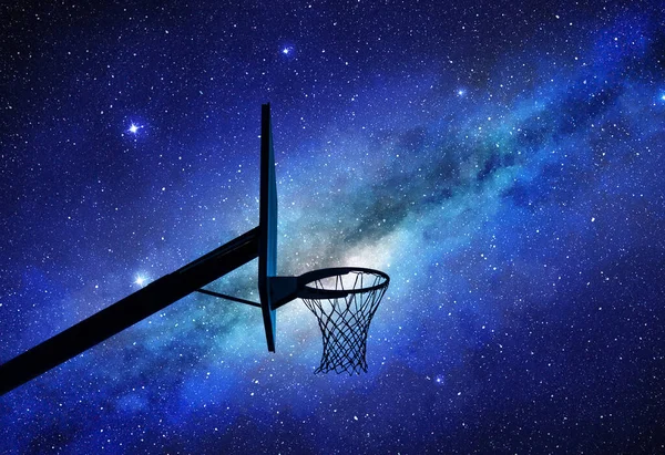 Basketball hoop silhouette at night with milky way in background
