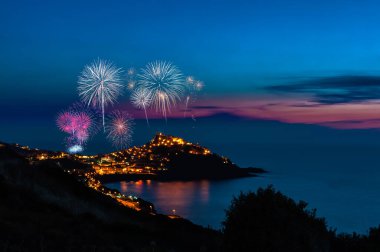 Geceleri havai fişeklerle Castelsardo şehrinin manzarası