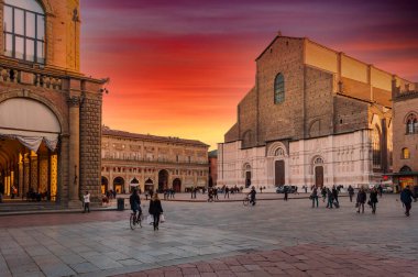 Bolonya 'daki Piazza Maggiore dramatik günbatımının kızıl gökyüzünün altında