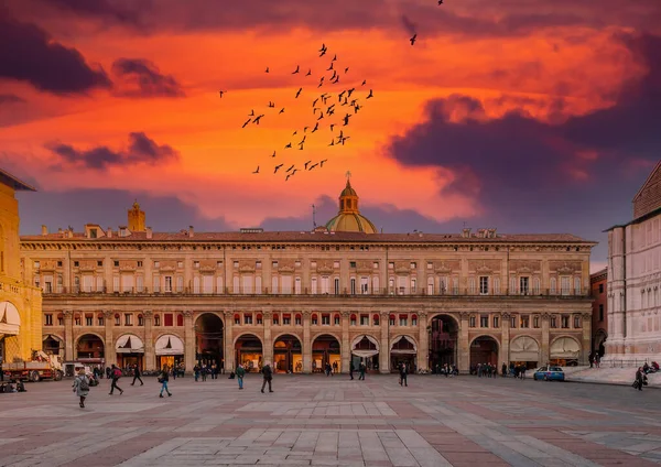 Bolonya 'daki Piazza Maggiore dramatik günbatımının kızıl gökyüzünün altında